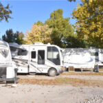 Three RVs parked near some trees in an RV Lot