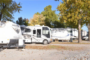 Three RVs parked near some trees in an RV Lot