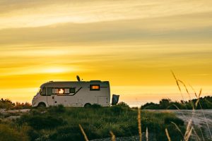 camper rv camping on coast nature in the morning at sunrise. holidays in spain, traveling with motor home.